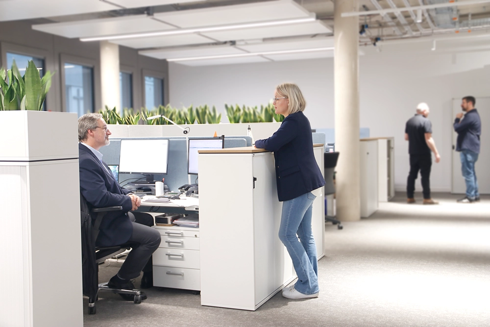 Bürosituation mit Mitarbeitenden im Gespräch.