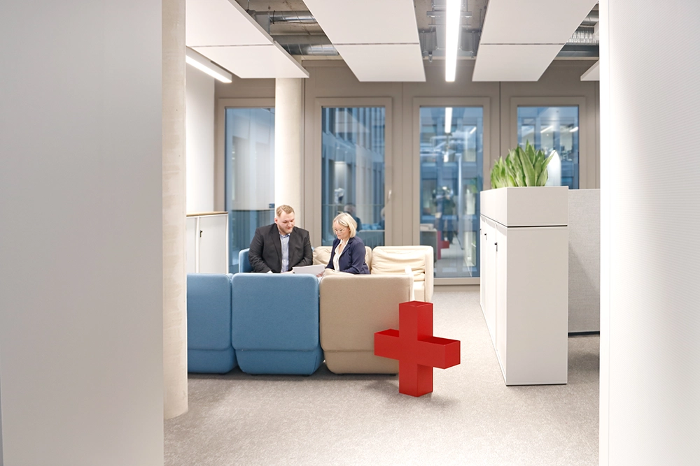 Team sitzt an Tisch und arbeitet gemeinsam.